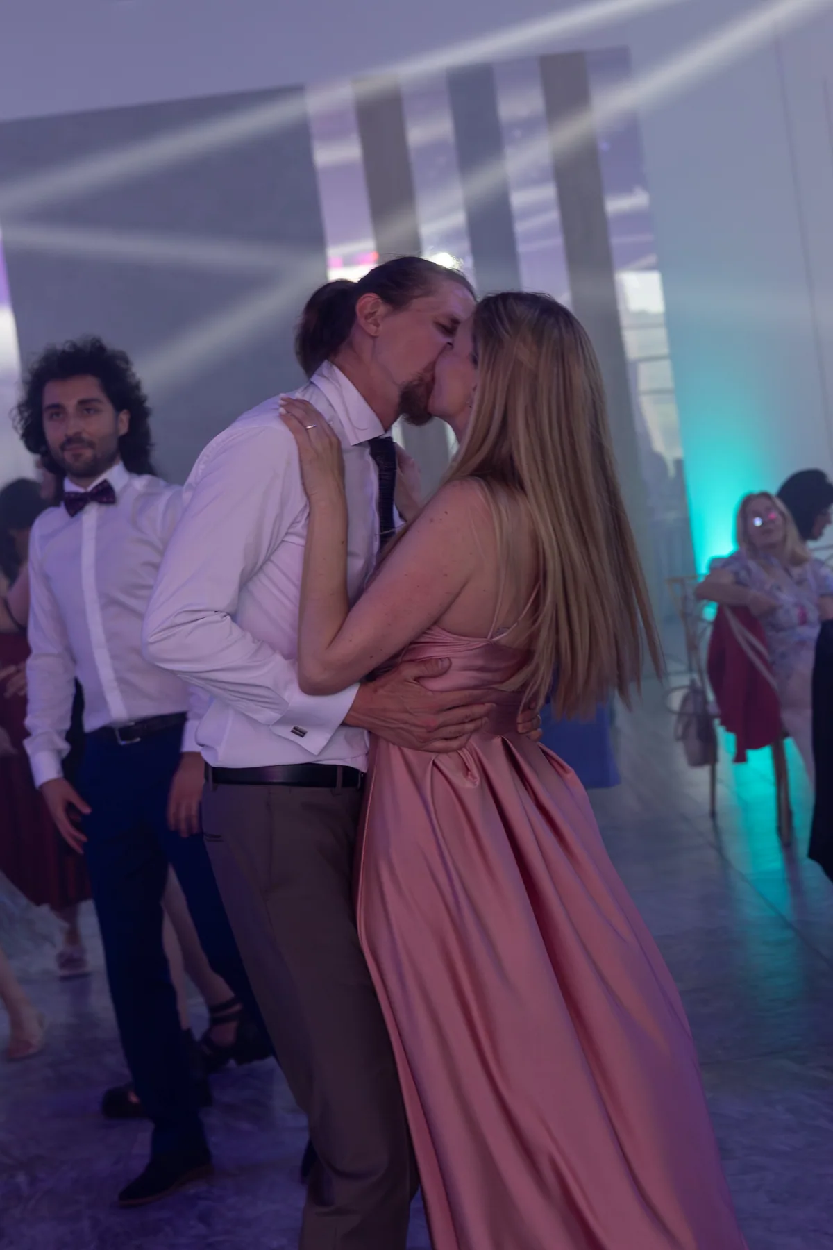 Doi invitați dansează sub luminile petrecerii.